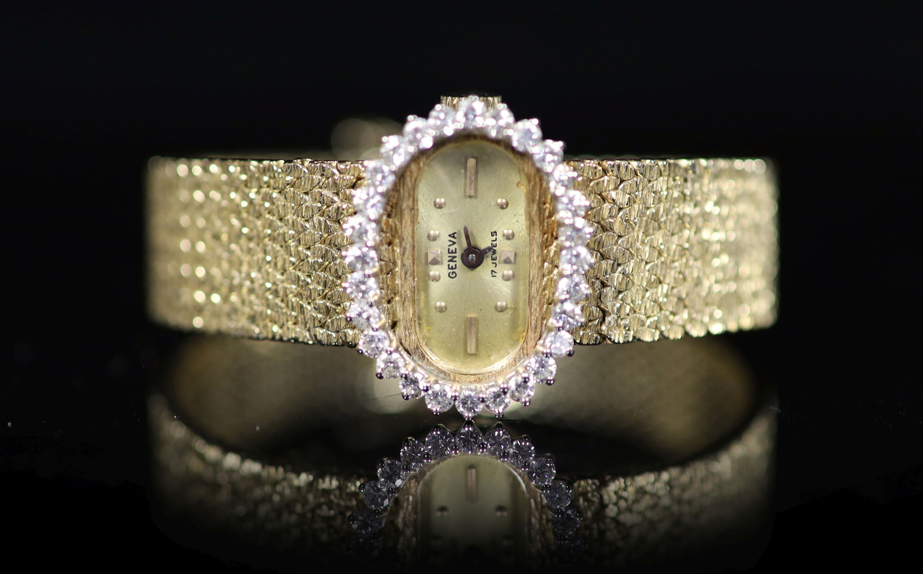 A lady's modern Swiss 14k gold and diamond set manual wind oval wrist watch, on integral 14k gold bracelet